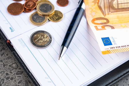 Money euro, notebook and pen on stone backgroundの写真素材