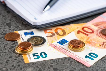 Money euro, notebook and pen on stone backgroundの写真素材