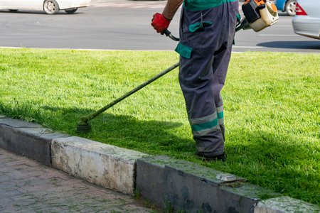 The gardener cutting grass by lawn mower, lawn care