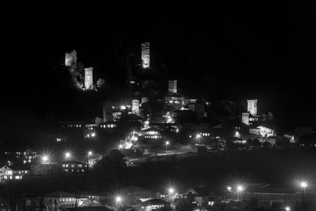 View of Svan towers with night illumination in Mestia village at night. Upper Svaneti, Georgia. Black and whiteの写真素材