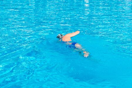 Woman with swimsuit swimming on a blue water pool. Sport.の写真素材
