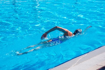 Woman with swimsuit swimming on a blue water pool. Sport.の写真素材