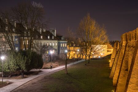 Warsaw, Poland Famous Barbican old town historic capital city and red orange brick wall fortress architecture at night. Travel.の写真素材