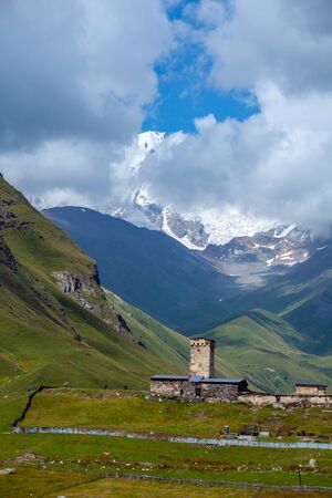 View of the Ushguli village at the foot of Mt. Shkhara. Lamaria Monastery, old Rock tower. Travel.の写真素材