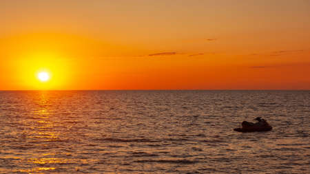 Water scooter on the water surface of the Black Sea at sunset, Poti, Georgia. Amazing sunset view.の写真素材