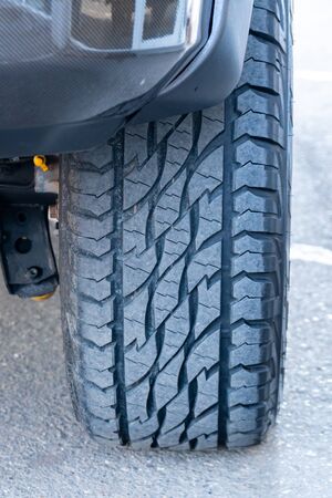 Car all-season tire close up, parked car. Low angle shot. Transportation