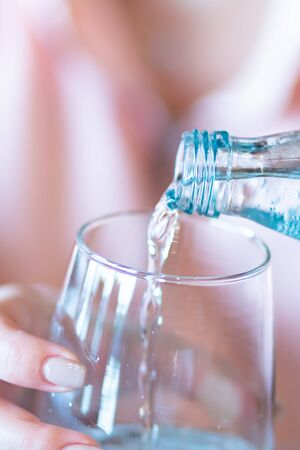 Woman's Hand Pouring Fresh pure Water From bottle. Drink.