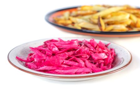 Tasty red sauerkraut or fermented cabbage in marinade and fried potato on a plate isolated on white.の写真素材