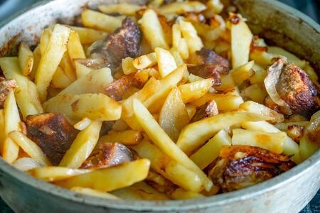 Potatoes and pork at home in a frying pan. Food.の写真素材