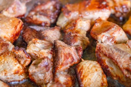 frying pork meat in a pan at home. Food.の写真素材