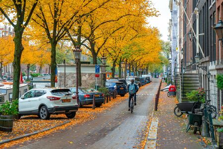 Amsterdam, Netherlands: cityscape of Amsterdam in colorful autumn, view to canal with boats, old colored houses. Travel.のeditorial素材