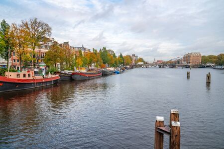 Amsterdam, Netherlands - October 15, 2019: Colorful houses and Boats on Amsterdam Canal. Autumn in Amsterdamのeditorial素材