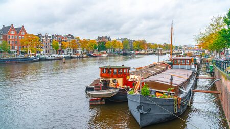 Amsterdam, Netherlands - October 15, 2019: Colorful houses and Boats on Amsterdam Canal. Autumn in Amsterdamのeditorial素材