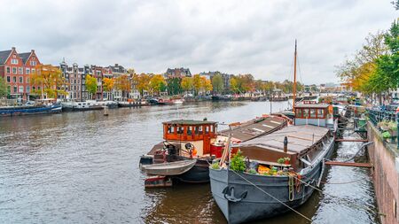 Amsterdam, Netherlands - October 15, 2019: Colorful houses and Boats on Amsterdam Canal. Autumn in Amsterdamのeditorial素材