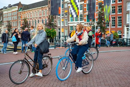 Amsterdam, Netherlands - October 14, 2019: People riding bicycles in historical part of Amsterdam. Travelのeditorial素材