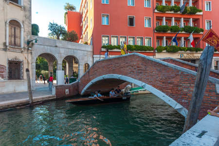 Venice, Italy - August 16, 2018: View of narrow Canal with boats and gondolas in Veniceのeditorial素材