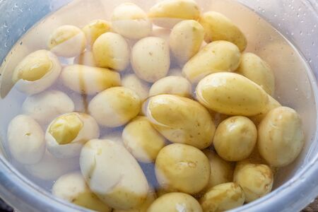 lots of fresh peeled whole potatoes in a bowl of water, foodの写真素材