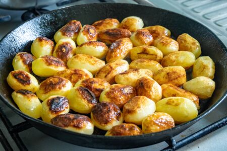 Small fresh potatoes fried in olive oil on frying pan, vegetableの写真素材