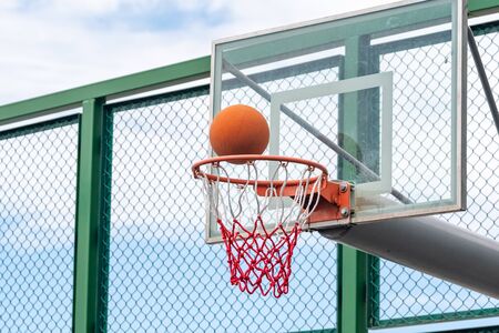 Basketball ring with a net and ball, outdoor playgroundの写真素材