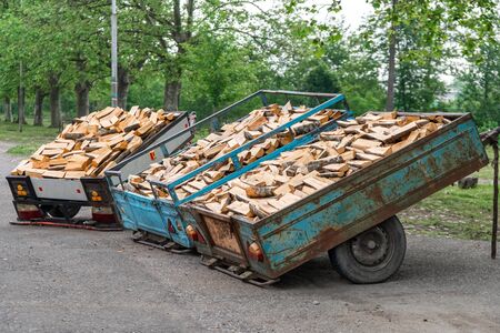 A pile of firewood and logs in an iron truck for saleの写真素材