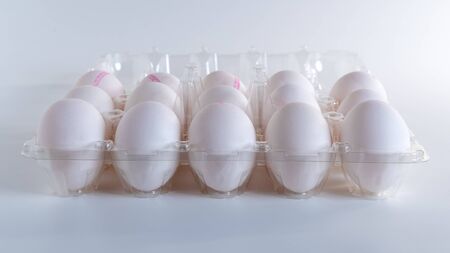 White eggs in a plastic package isolated white background, foodの写真素材