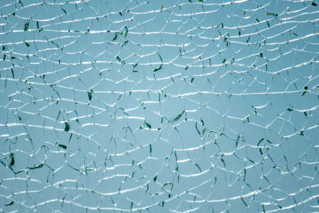 Cracks in the glass. Broken glass on blue background, texture design object.