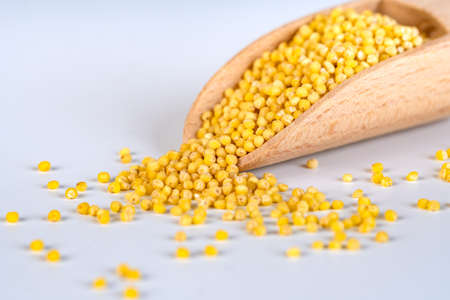Wooden spoon with millet isolated on whiteの写真素材