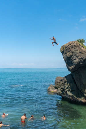 Tsikhisdziri, Georgia - 07 August, 2020: Man jumping from high rock to the see, Georgia. Black Sea