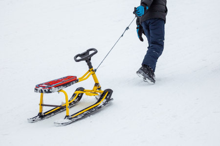 People with sledge climbing at the snowy hill on winter park in Bakuriani, Georgiaの写真素材