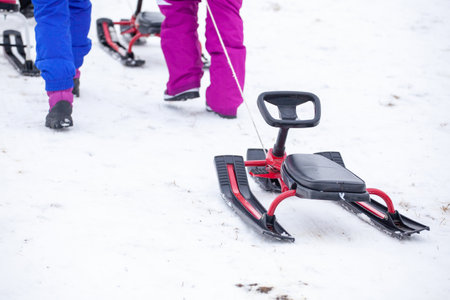 People with sledge climbing at the snowy hill on winter park in Bakuriani, Georgia