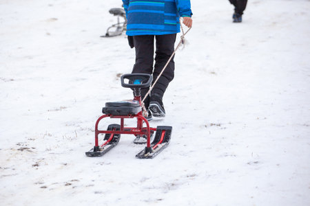 People with sledge climbing at the snowy hill on winter park in Bakuriani, Georgia