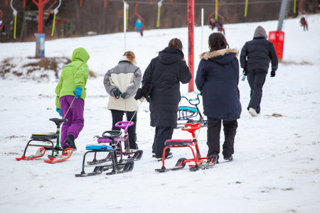 People with sledge climbing at the snowy hill on winter park in Bakuriani, Georgiaの写真素材