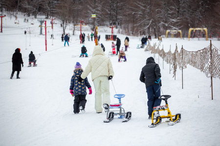 People with sledge climbing at the snowy hill on winter park in Bakuriani, Georgiaの写真素材