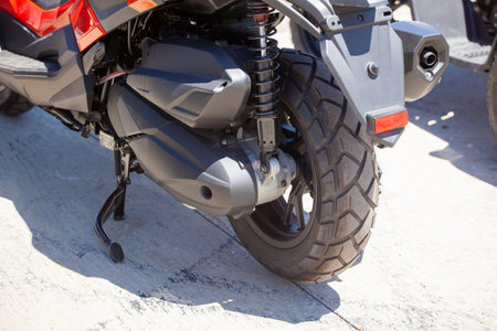 Rear wheel of a sports motorcycle with an exhaust pipe standing on the asphalt. Motor sportの写真素材