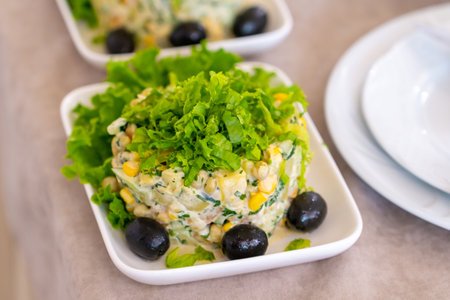 Traditional Russian salad "Olivier" With olives, lettuce leaves and various vegetables. Healthy foodの写真素材