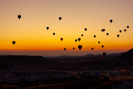 Hot air balloon flying over rocky landscape at sunrise in Cappadocia. Travelの写真素材