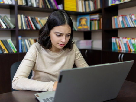 Teenage school girl working on a computer in the library. Educationの写真素材