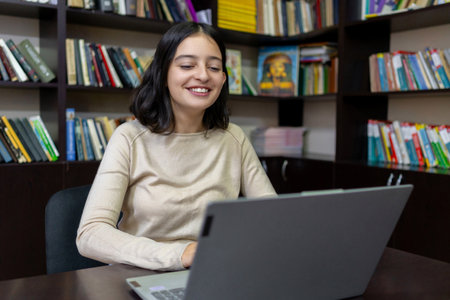 Teenage school girl working on a computer in the library. Educationの写真素材