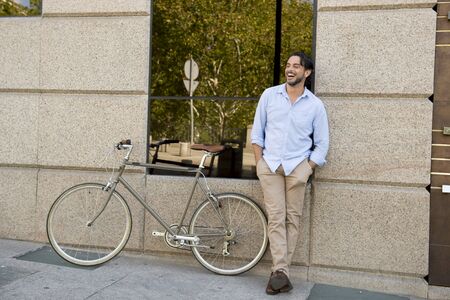 young happy attractive latin man in casual trendy clothes smiling cheerful riding on vintage cool...