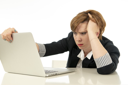 Young beautiful caucasian stressed business woman working on her laptop looking worried, tired, overwhelmed and unhappy. business, overwork, deadline and technology concept.の写真素材