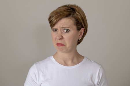 Close up beautiful young red haired caucasian woman with a disgusted expression. feeling dislike or...