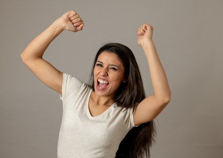 Young beautiful latin happy euphoric and excited woman celebrating winning the lottery. Positive human facial expressions and emotions. People success, life perception, achievementの写真素材