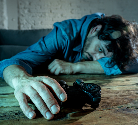 Addiction and dependency concept. close up on young mans hand with pad joystick playing video games Male addicted to console gaming concept.の写真素材