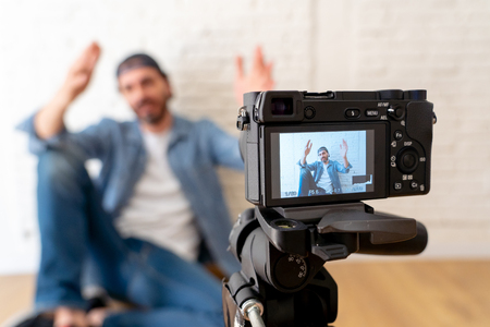 close up young happy male blogger on camera screen filming a video for the internet in technology conceptの写真素材