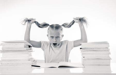 Beautiful school girl trying to study having too many homework that It's driving her crazy in motivation low performance children education concept isolated on white backgroundの写真素材