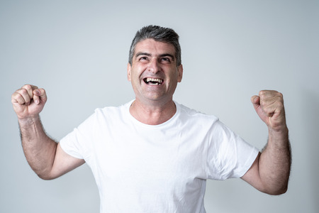 Man rejoices in achieving his goal, wining the lottery or having great success in face expression human emotions surprised and happy facial expression isolated on grey background.の写真素材