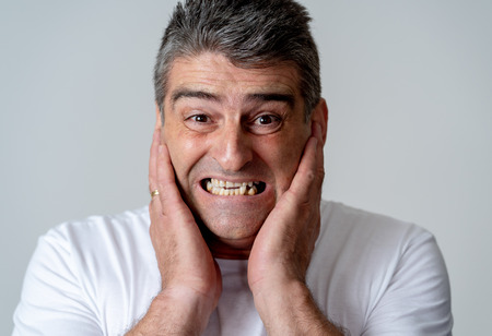 Portrait of a 40s 50s man in shock with a scared expression on his face making frightened gestures in human emotions feelings and facial expression concept isolated on grey background.の写真素材