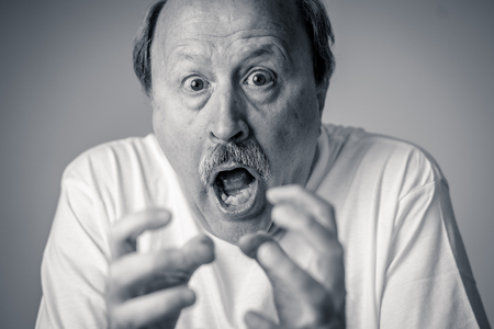 Close up portrait of a scared frightened old man in expression of fear in human emotions and facial expressions isolated in neutral background.の写真素材