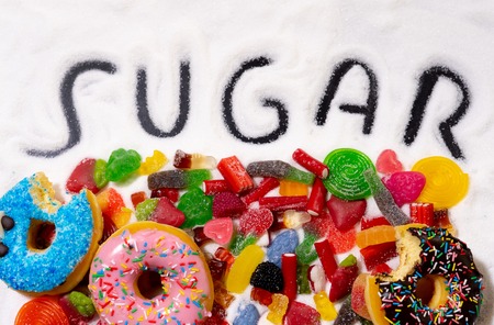 Colorful selection of different child sweets candies and treats with sugar written metaphor of too much sugar causes Health problems Nutrition Obesity Diabetes Dental care and Sugar addiction.の写真素材