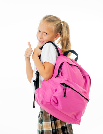 Pretty cute blonde hair girl with a pink schoolbag looking at camera showing thumb up gesture happy to go to school isolated on white background in back to school and children education concept.の写真素材